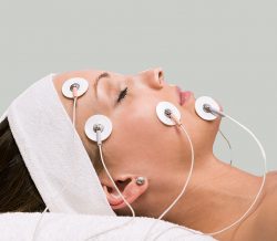 Portrait of a young woman lying  with electrodes on her face